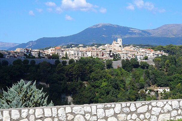 a stone wall and a village in the background