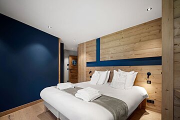A bedroom with a bed and a blue wall