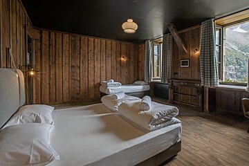 A bedroom with wood paneled walls and two beds