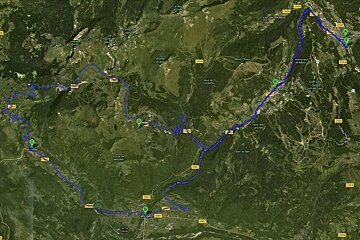 An aerial view of a mountainous area with a road going through it