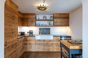 A kitchen with wooden cabinets and a white sink