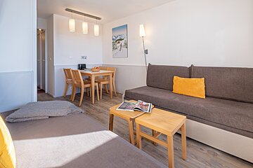 A living room with a couch a table and chairs