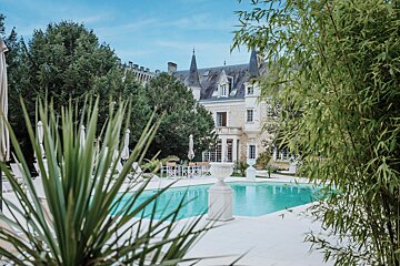 A large house with a swimming pool in front of it