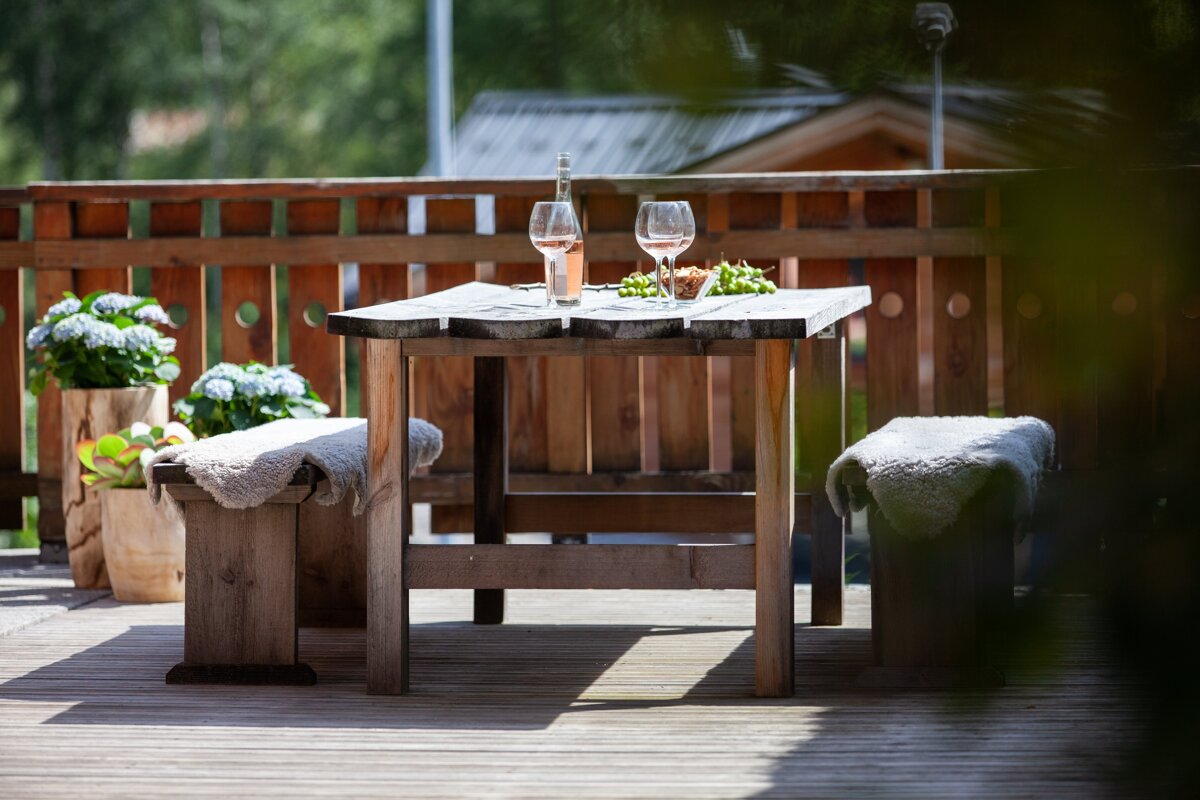 A wooden table with a bottle of wine and two glasses on it