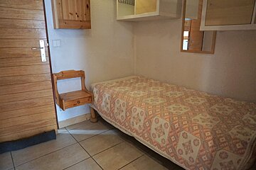 A small bedroom with a bed and a nightstand