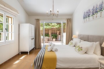 A bedroom with two beds and a painting of flowers on the wall