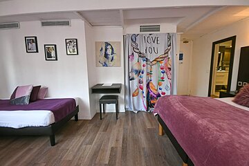 A bedroom with two beds and a curtain that says i love you