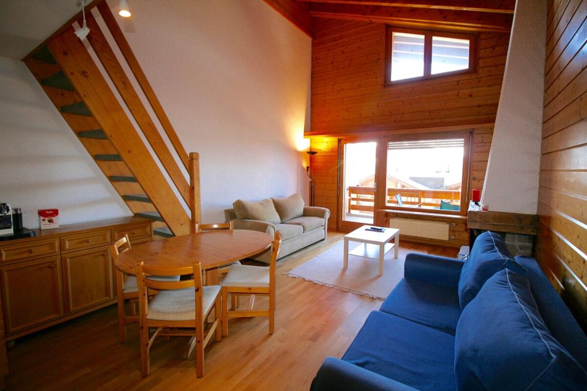 A living room with a couch a table and chairs