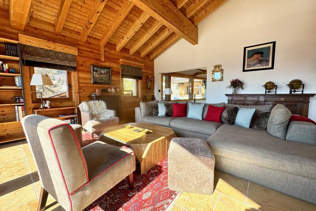 A living room with a large sectional couch and chairs