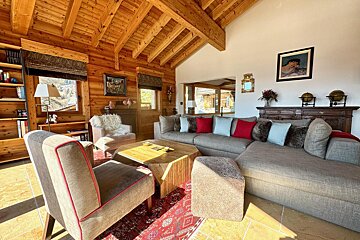 A living room with a large sectional couch and chairs