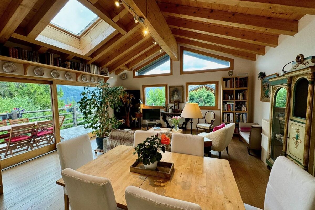 A living room with a table and chairs and a skylight