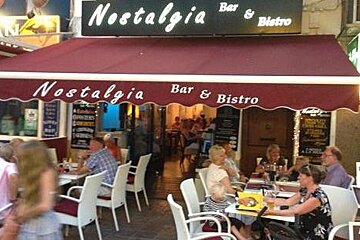 filled tables and seats outside a bar in pollenca