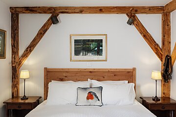 A bed with a pillow with a bird on it