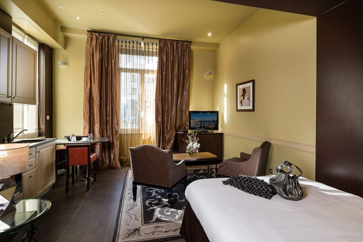 A hotel room with a bed and a television