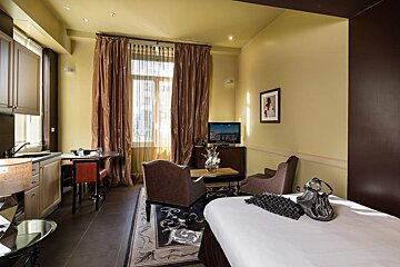 A hotel room with a bed and a television