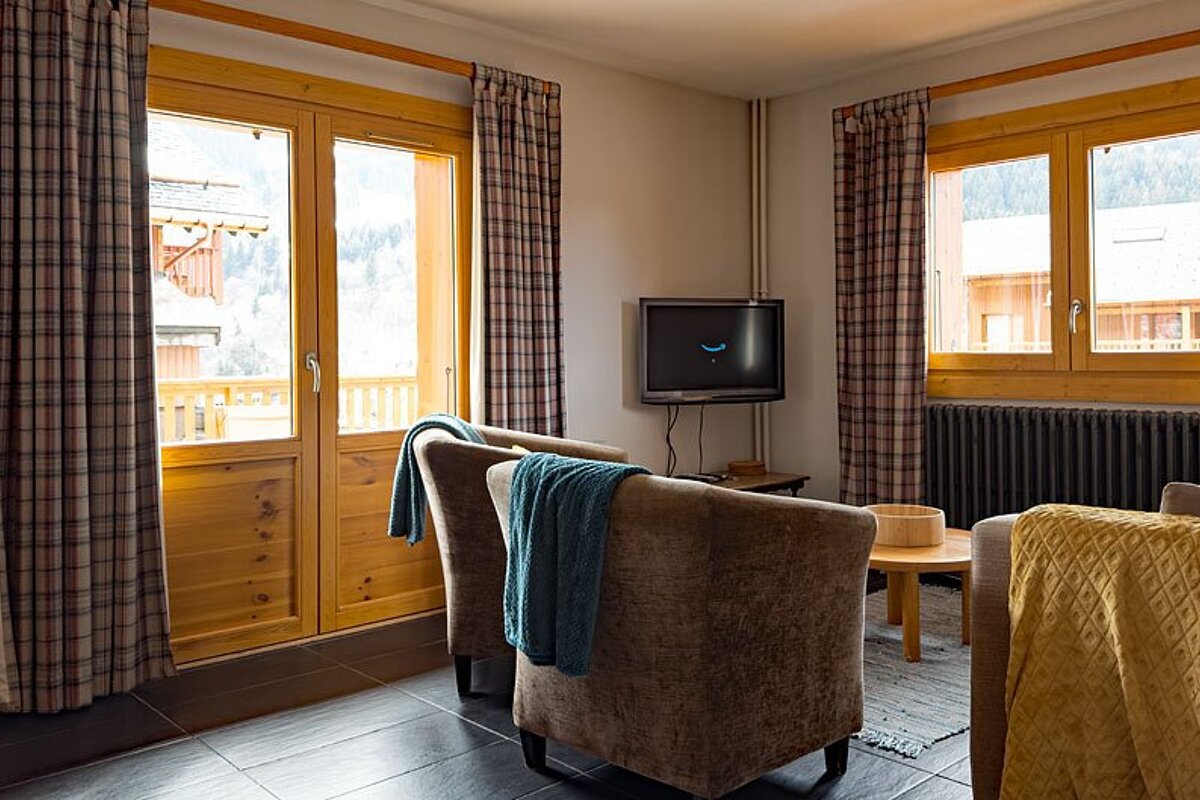A living room with two chairs and a flat screen tv