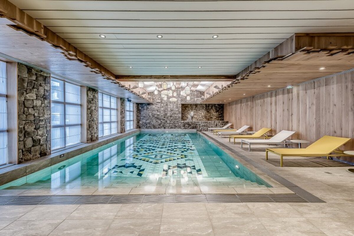 A large indoor swimming pool with chairs around it