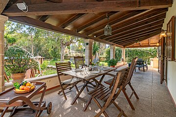 A patio with a table and chairs and a cart with fruit on it