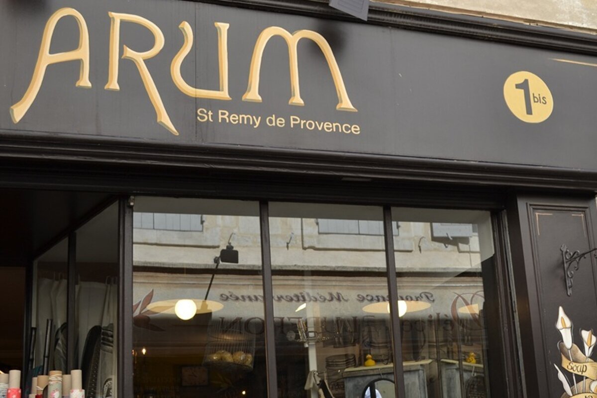 Image of a shop front of Arum in St Remy, brown front with gold writing
