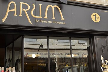 Image of a shop front of Arum in St Remy, brown front with gold writing