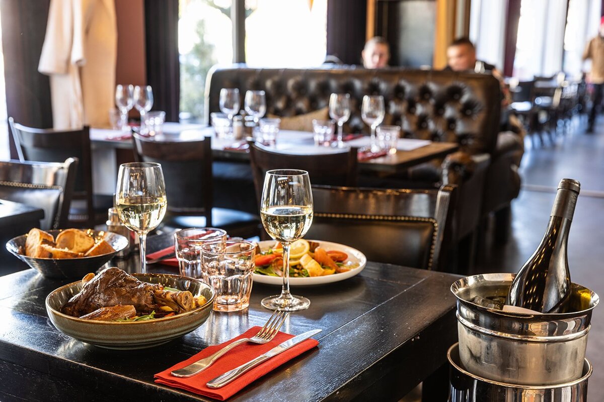 A bottle of wine sits on a table in a restaurant