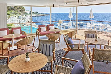 A restaurant with tables and chairs overlooking the ocean