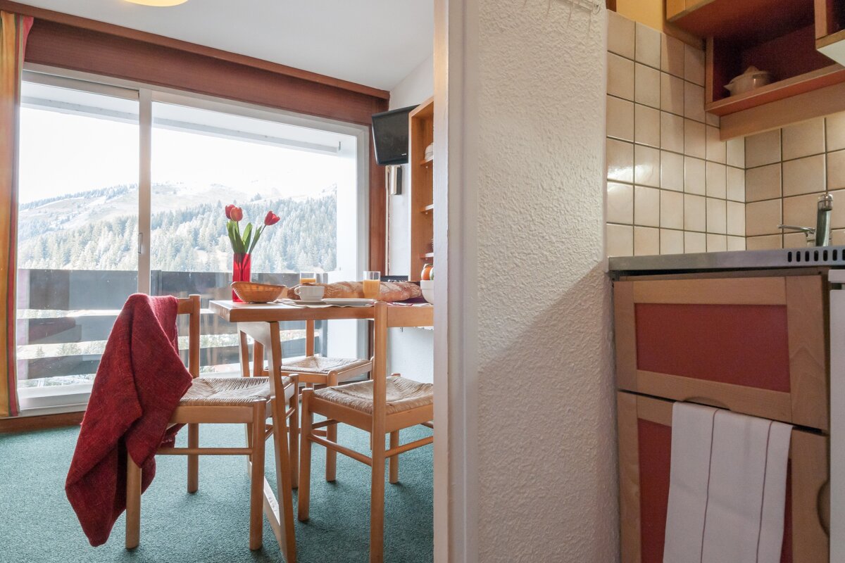 A room with a table and chairs and a sliding glass door