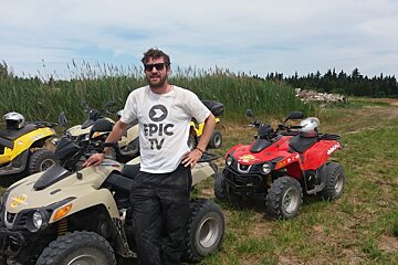 a man in a white t-shirt next to a quad bike