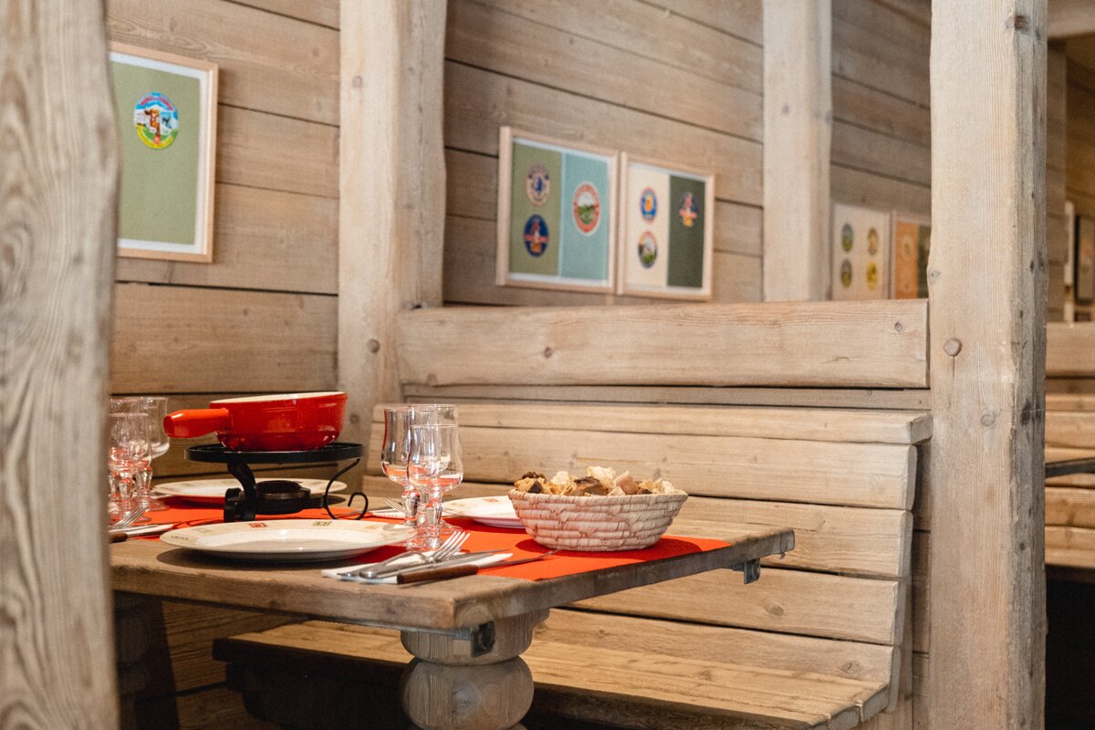 A wooden table with a bowl of bread on it