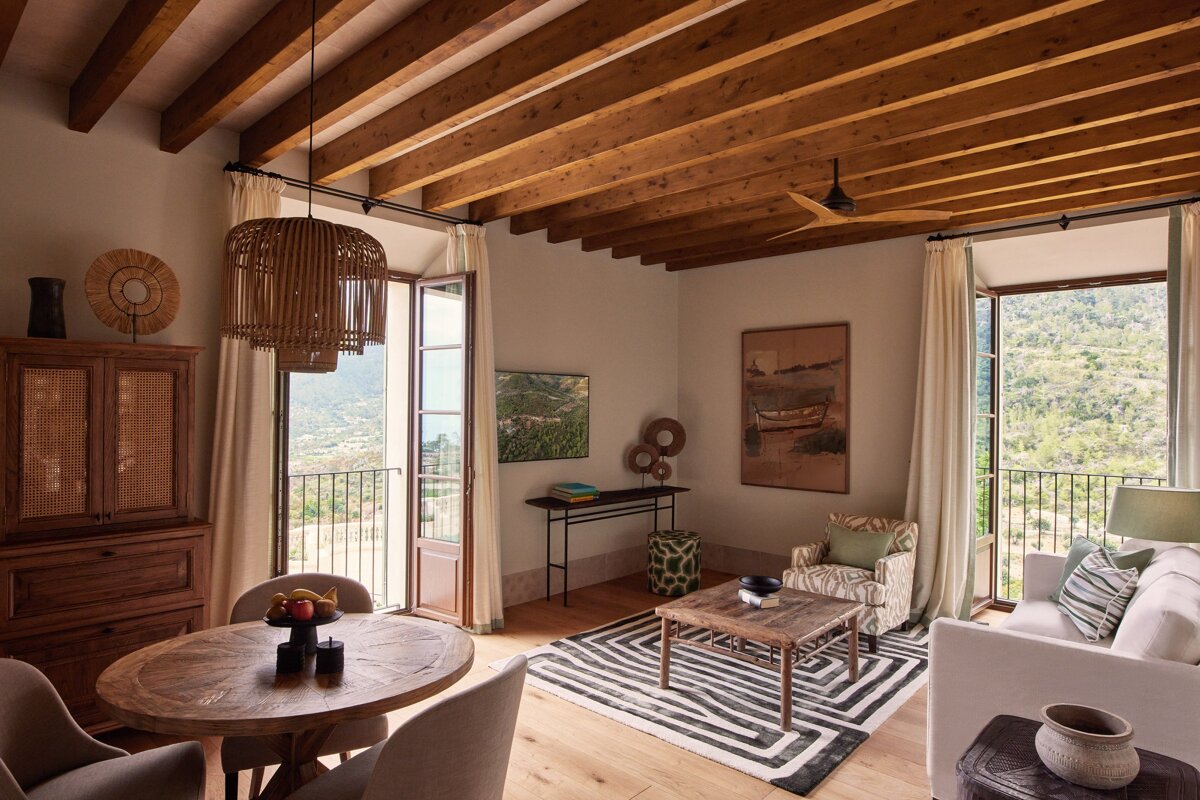 A living room with a table and chairs and a painting on the wall