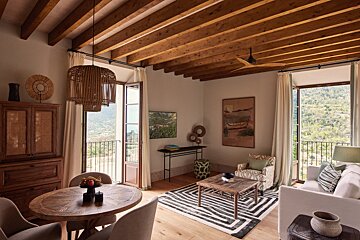 A living room with a table and chairs and a painting on the wall