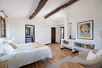A bedroom with a large bed and a poster on the wall