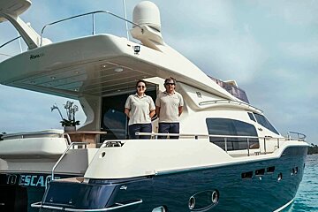 Two people standing on the deck of a boat that says to escape