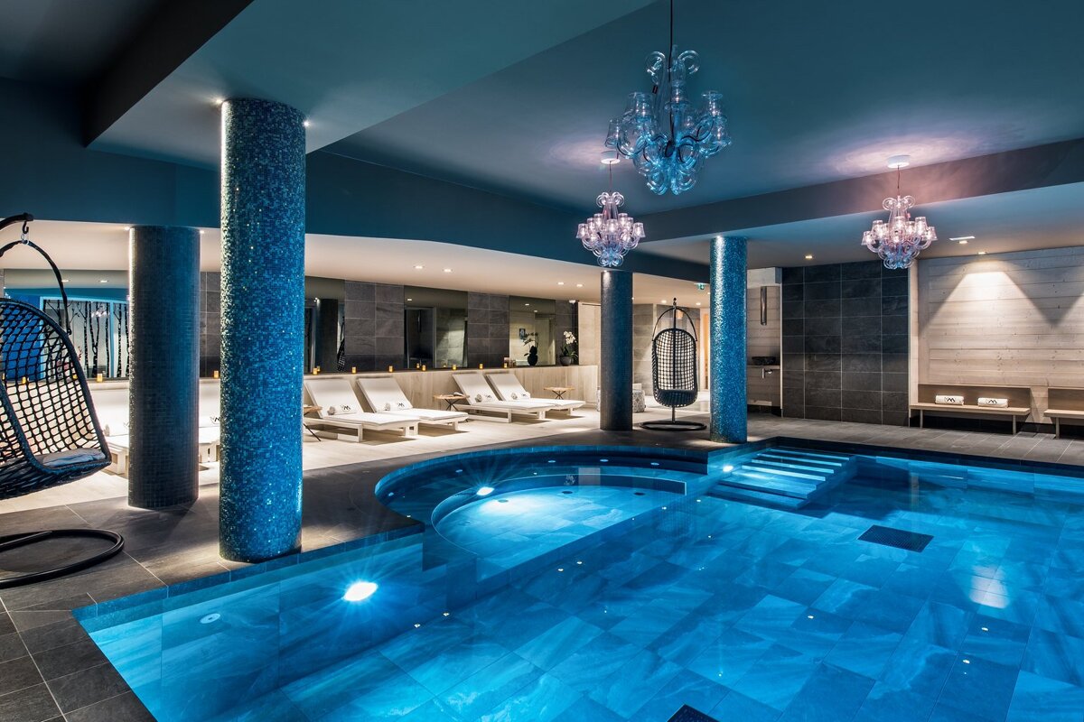 A swimming pool with a chandelier hanging from the ceiling