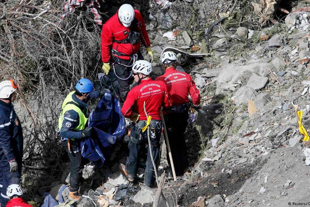 men in helmets working on a plane crash site