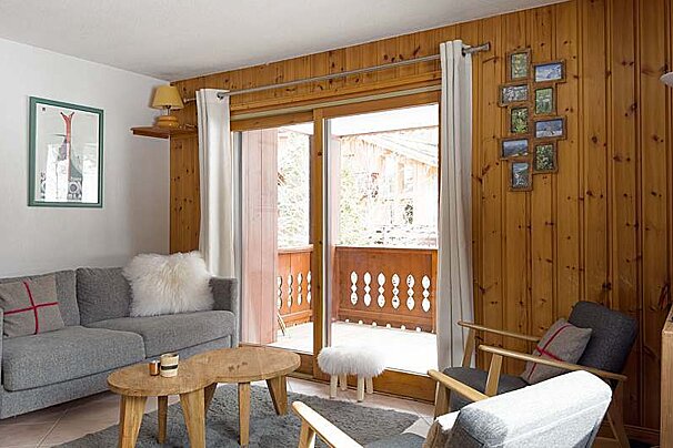 A living room with a couch and chairs and a balcony