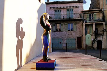 a modern sculpture & old buildings behind in biot