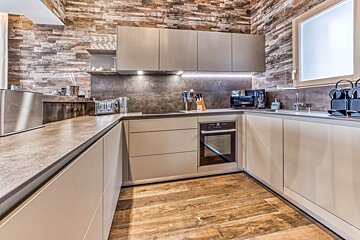 A kitchen with stainless steel appliances and wooden floors