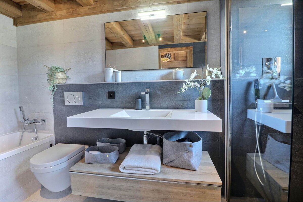 A bathroom with a toilet a sink and a mirror