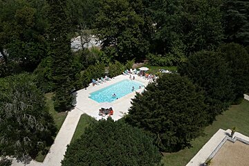 An aerial view of a swimming pool surrounded by trees