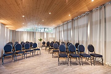 Rows of chairs in a room with white curtains