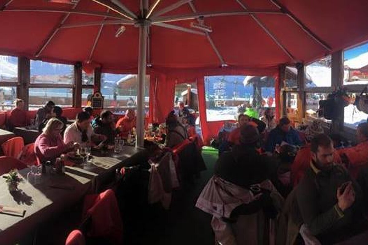 a red tent with dining tables inside 