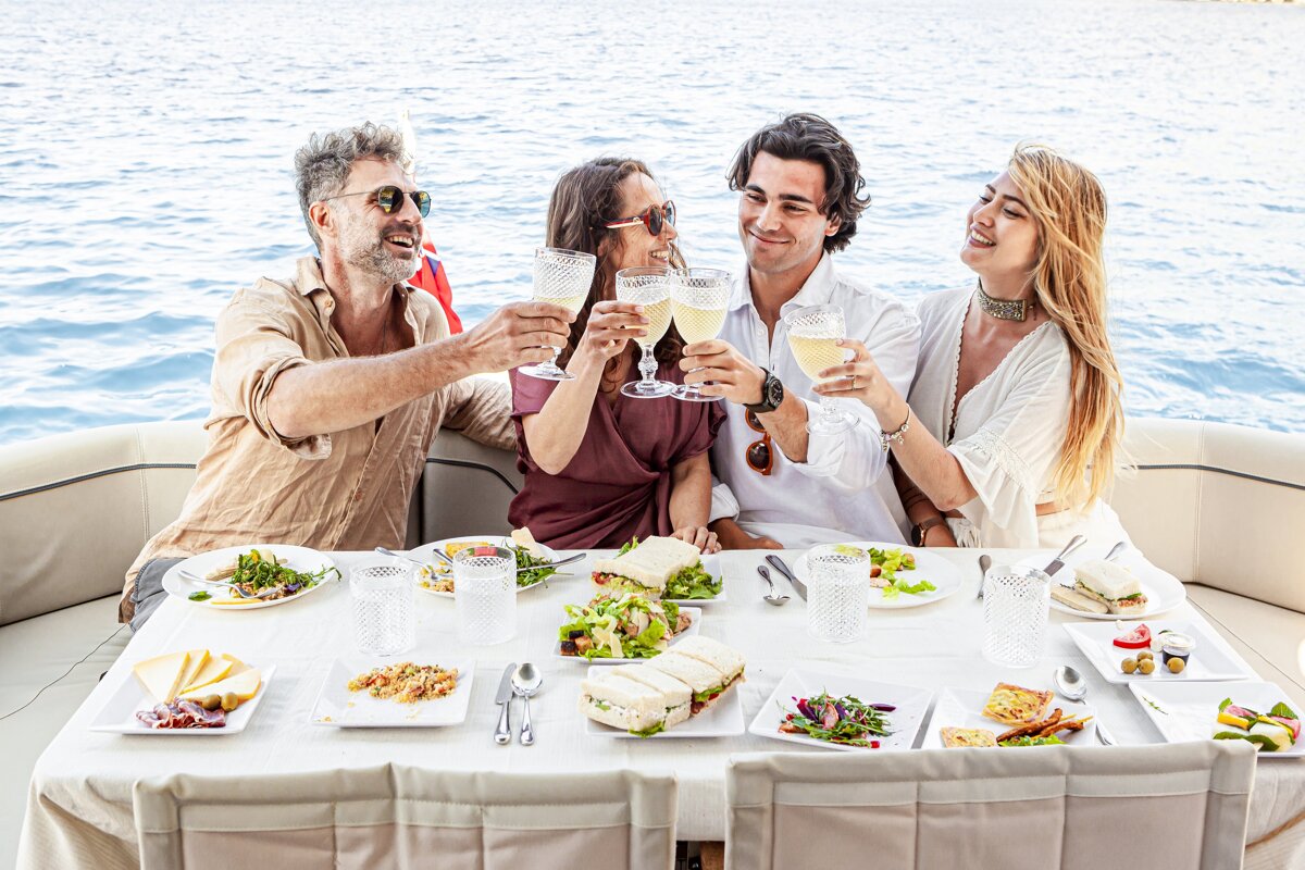 A group of people are sitting at a table toasting with champagne glasses