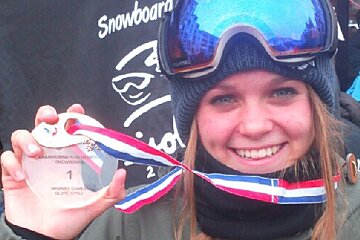 a snowboarder holding a medal