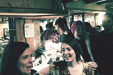lots of people in a bar smiling at the camera