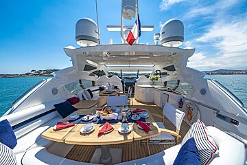 The front of a yacht with a table and chairs set up