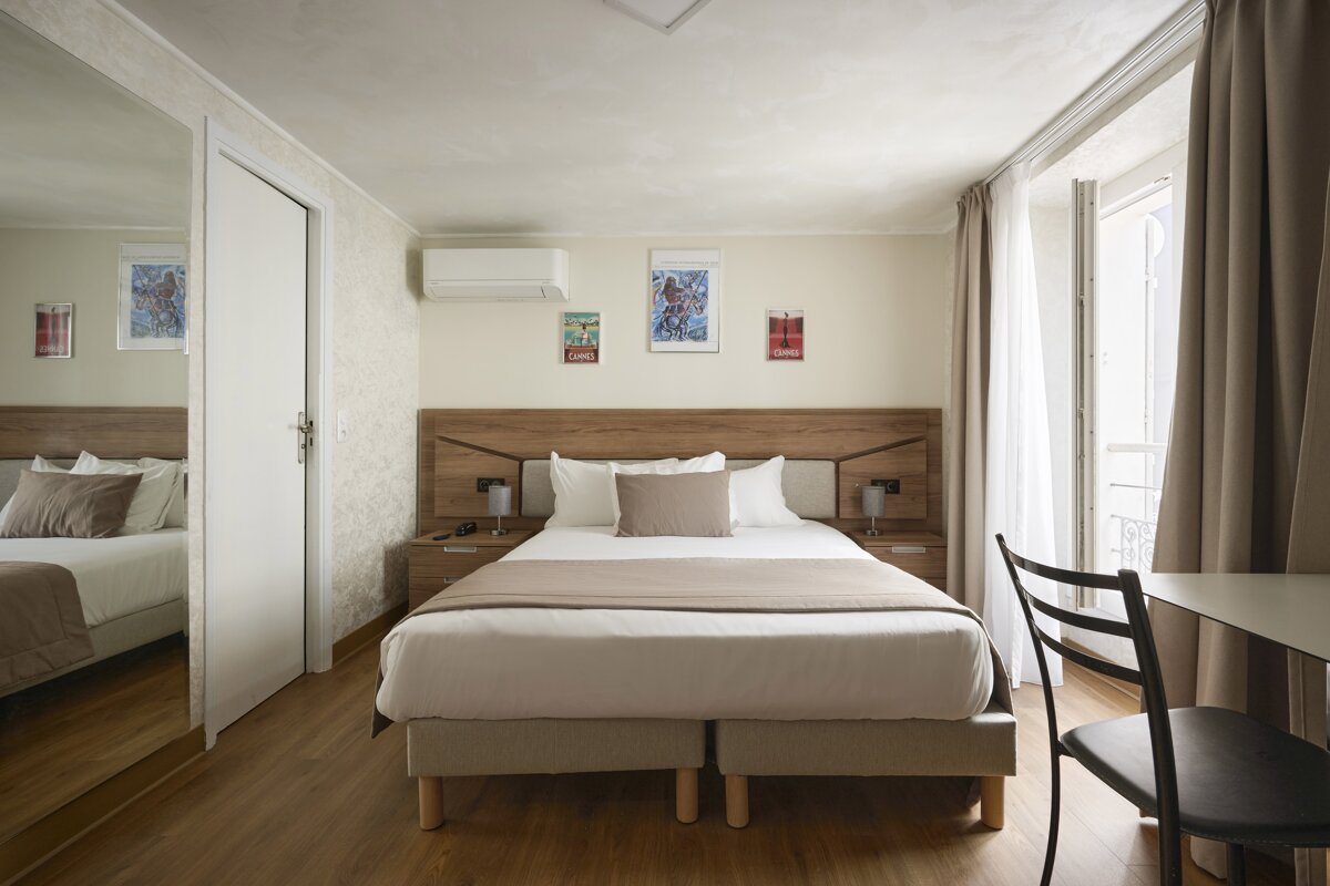 A hotel room with a bed and a chair