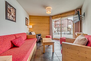 A living room with a red couch and a tv