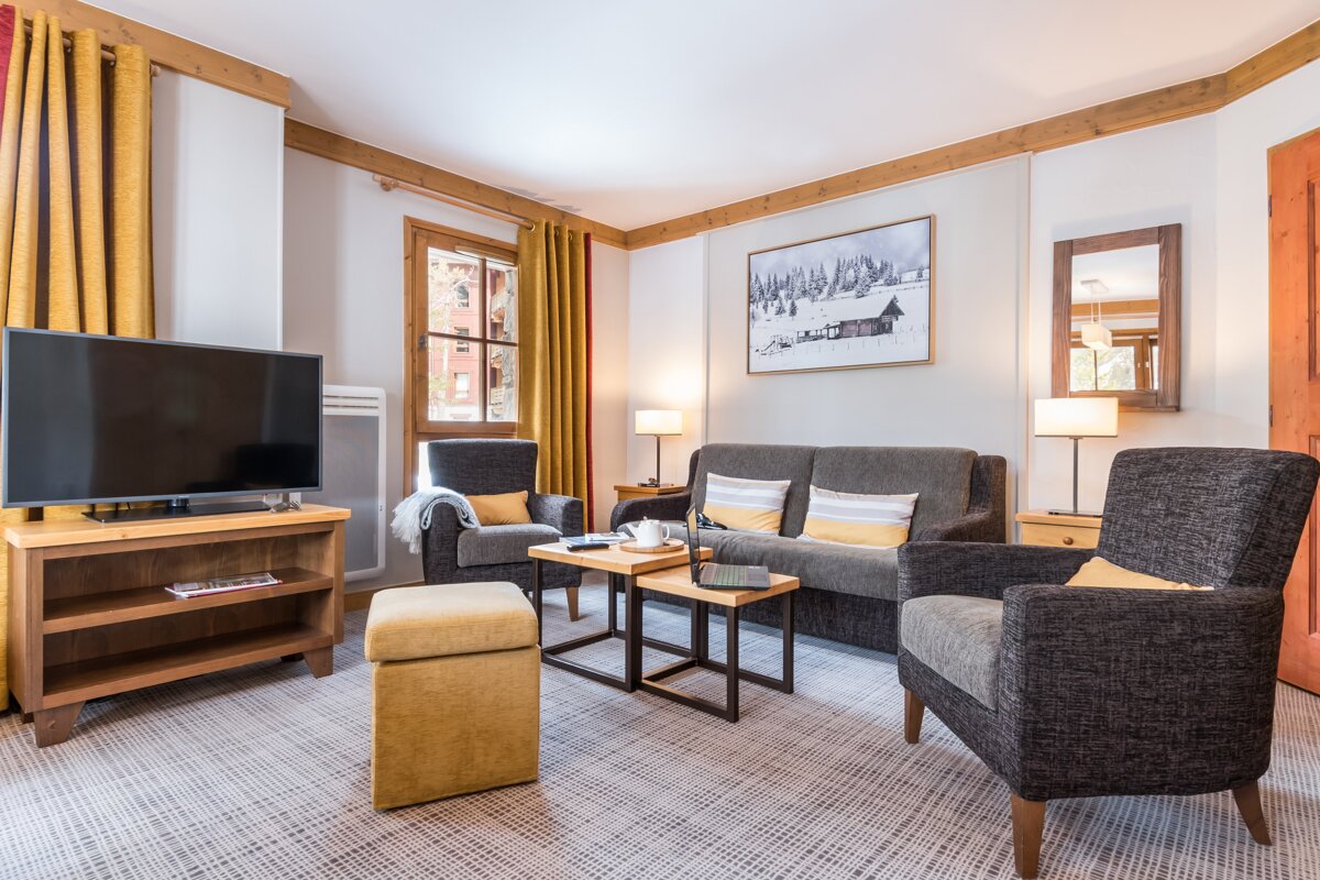 A living room with a couch a chair and a flat screen tv