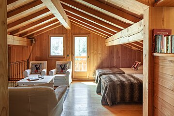 A wooden room with two beds and a book titled responsible living